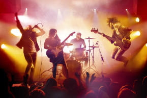 Immagine di un palco con fari a luce gialla di un concerto rock
