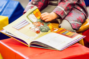 una bambina sfoglia le pagine di un libro illustrato